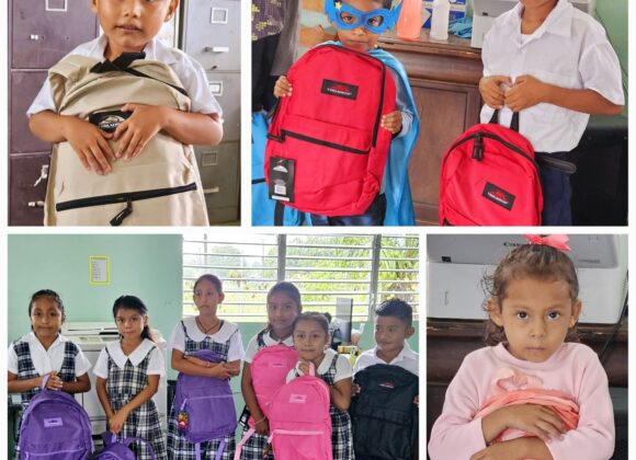 Belizean pupils holding new backpacks and school supplies