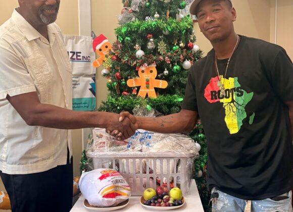 A Build Belize representative handing a holiday gift basket to a community member
